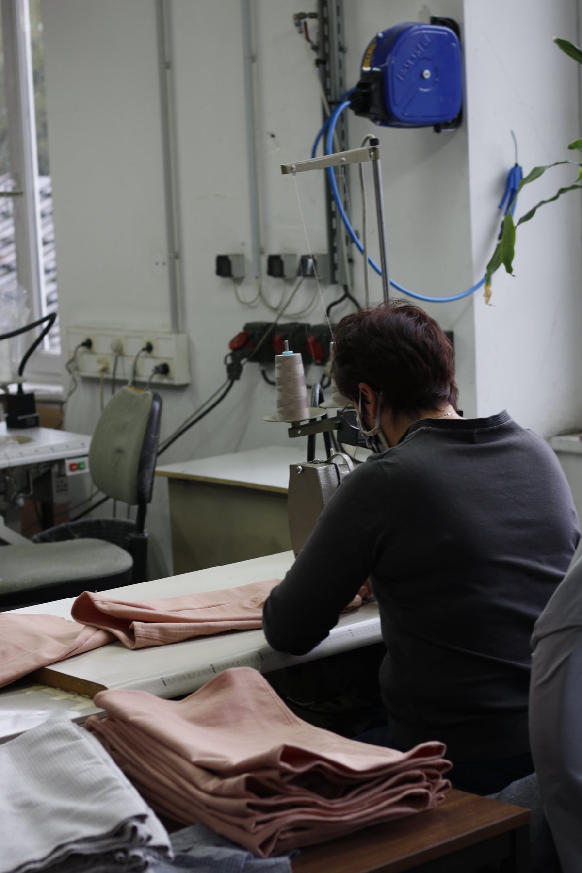 Une couturière travaille des pièces de tissu à sa machine